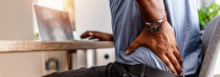 A man holding his lower back in pain.