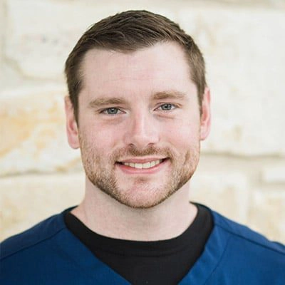 Carlson Thwing smiling in front of a stone wall.