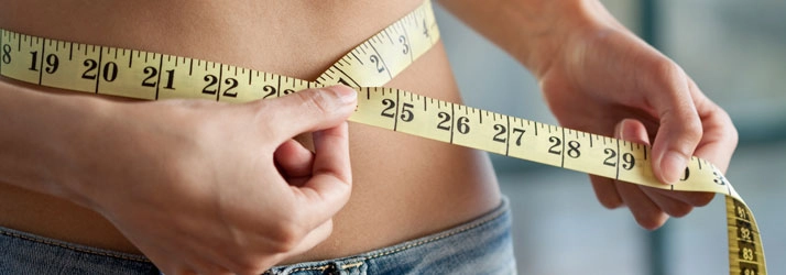 A person measuring their waist.